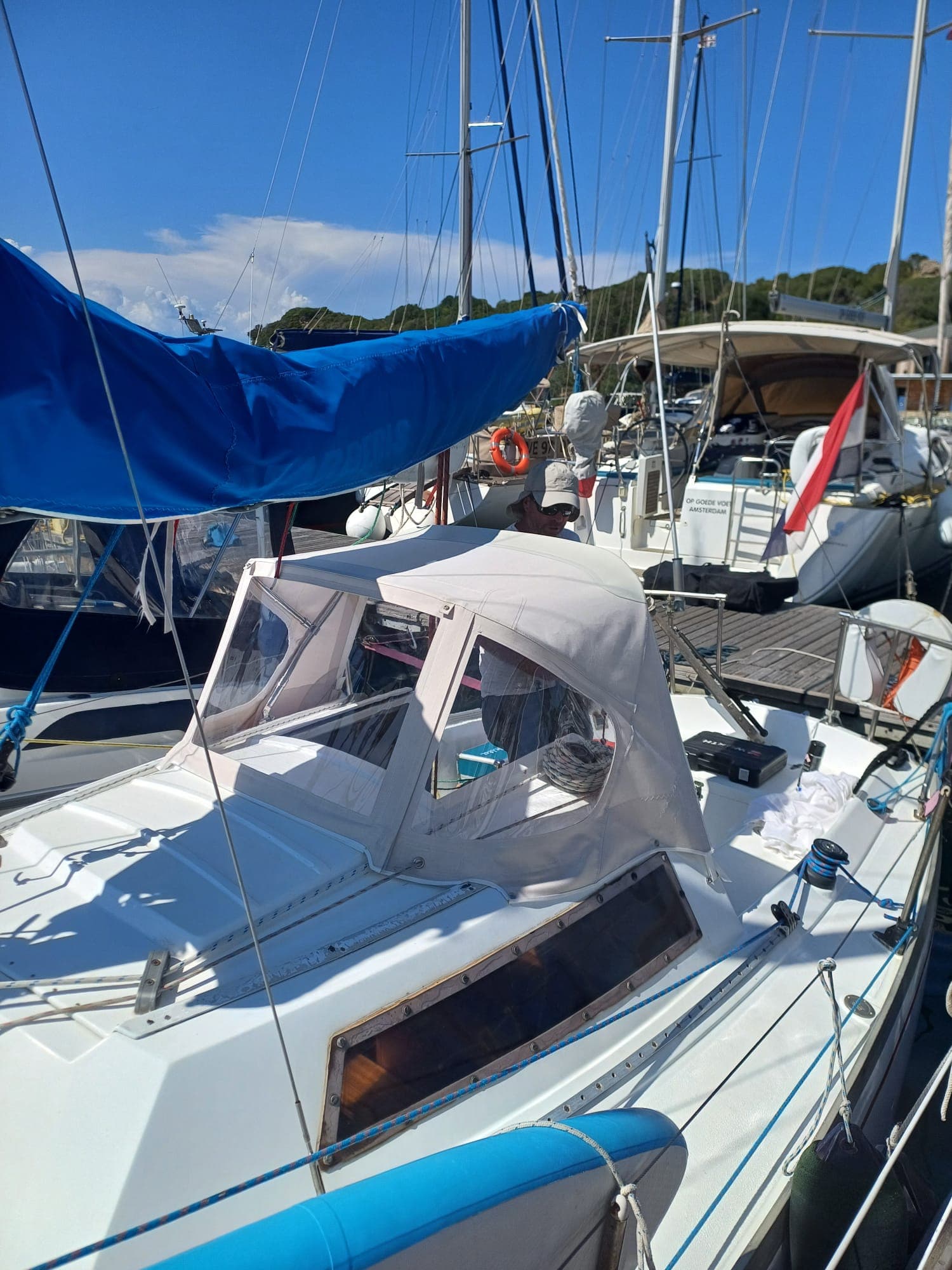 Sprayhood bianco su barca a vela, artigiano al lavoro in porto