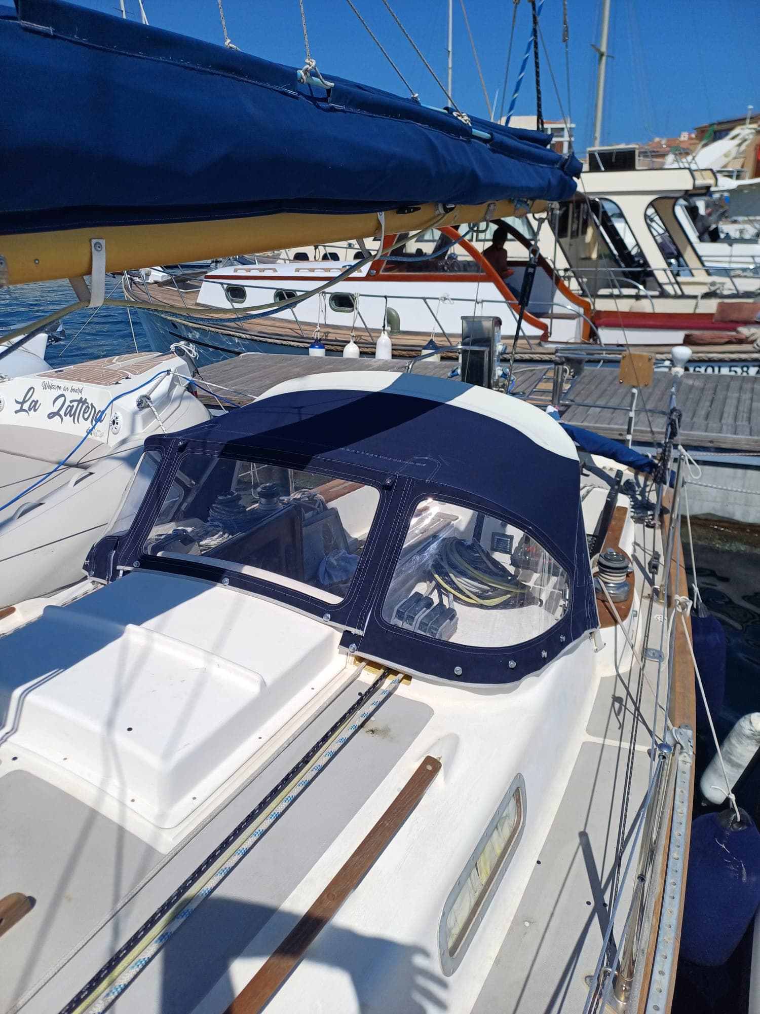 Sprayhood blu navy su barca a vela, vista laterale in porto