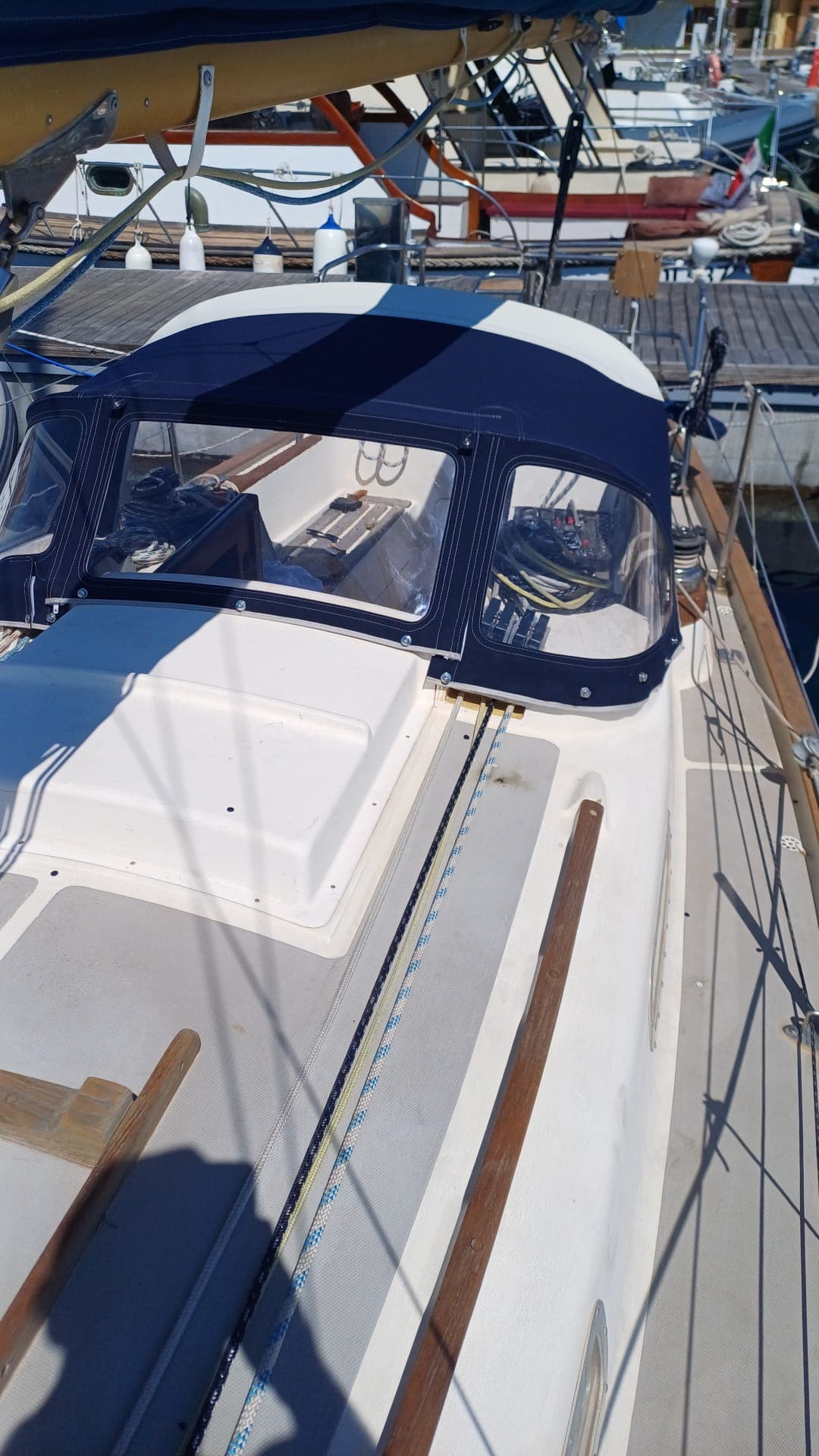 Sprayhood blu navy su barca a vela, vista da prua in porto