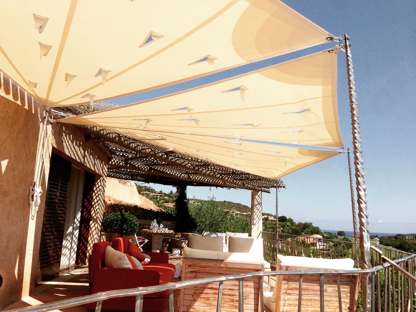 Vele ombreggianti su terrazza con poltrone rosse e vista mare, Costa Smeralda — portfolio WSAIL Sardegna